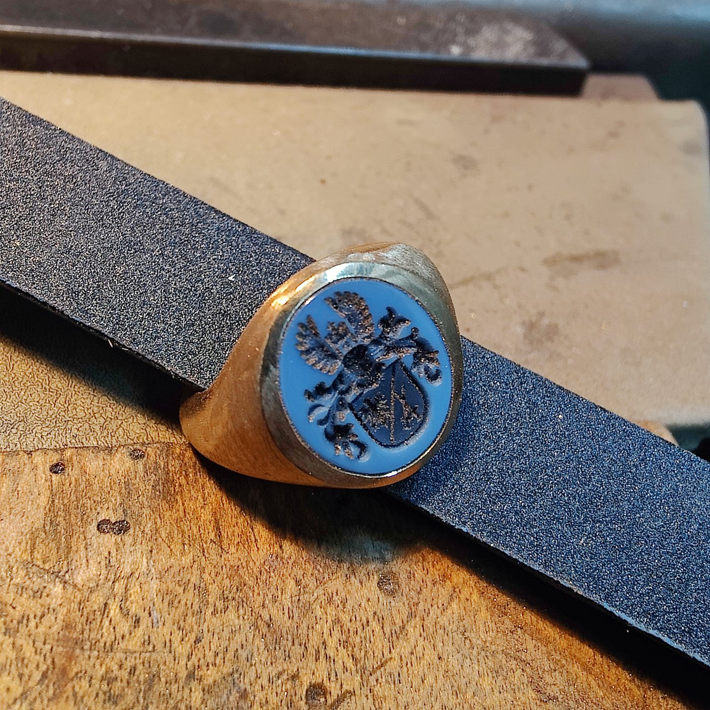Siegelring mit blauem Lagenstein in der Werkstatt auf dem Schleifband